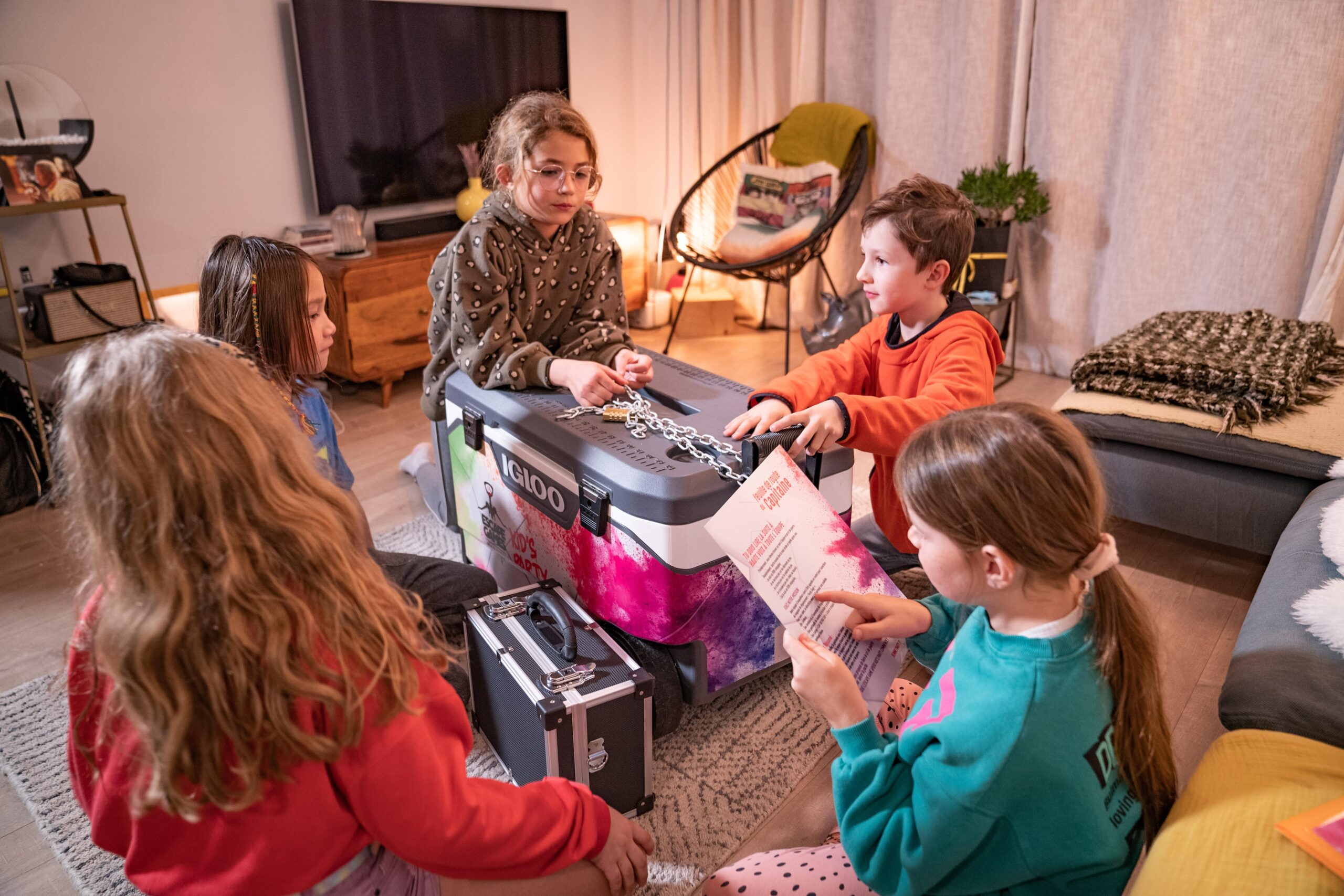 Groupe d'enfants autour de la glacière Kids Party, ils décryptent les énigmes pour déguster les produits normands